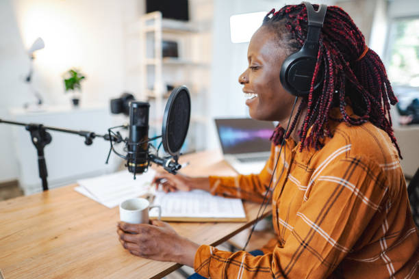 istock African woman recording podcast, talking on microphone 1477040842