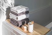 Bath spa soap towels pile soft textile cotton washcloth on wooden tabletop at sunny bathroom