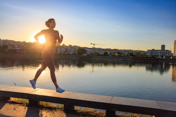 istock Woman running on platform by the city river at sunset 1477043633