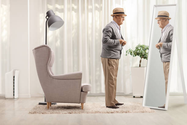 istock Senior gentleman getting dressed in front of a mirror at home 1477044357