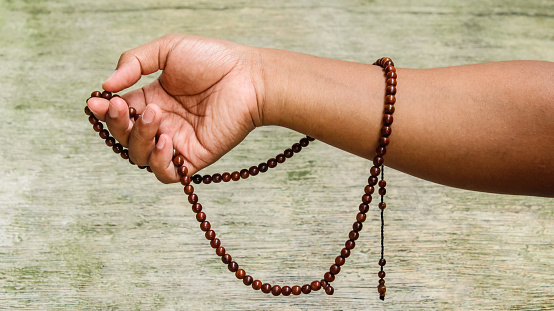 image of hands wrapped prayer beads
