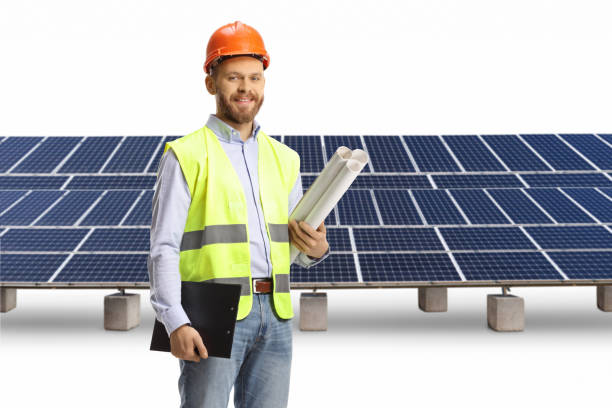 istock Young male engineer holding blueprints and clipboard on a solar panel field 1477046458