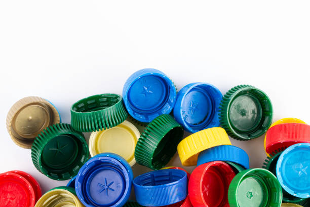 istock Multicolored plastic bottle caps are scattered on a white background. Plastic recycle place for text. 1477046764