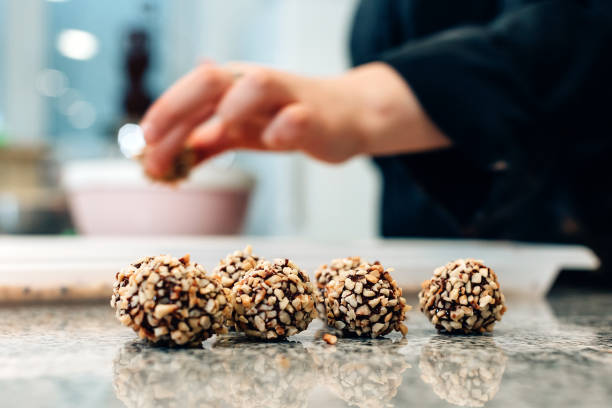 istock Pastry chef working inside chocolatier bakery workshop - Focus on pralines 1477052734