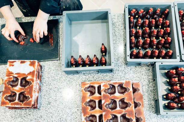 Pastry chef at artisanal decorating chocolate sweets at dessert workshop