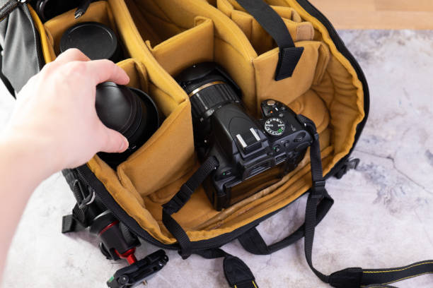 istock Man packing camera lens to his bag. 1477061033