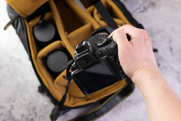 istock Man packing camera lens to his bag. 1477061044