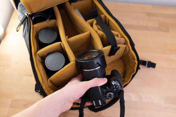 istock Man packing camera lens to his bag. 1477061046