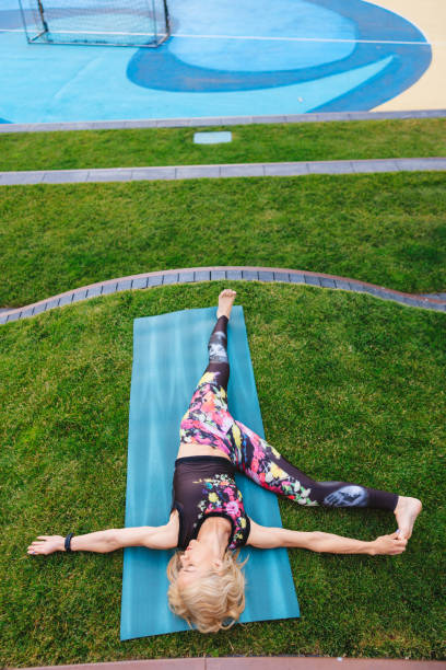 istock Mature woman practicing yoga in Side stretch pose, springtime in the park 1477061452