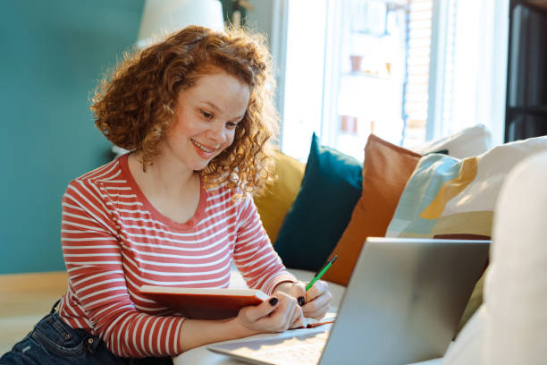 istock Female student using laptop and listening to online course 1477061555