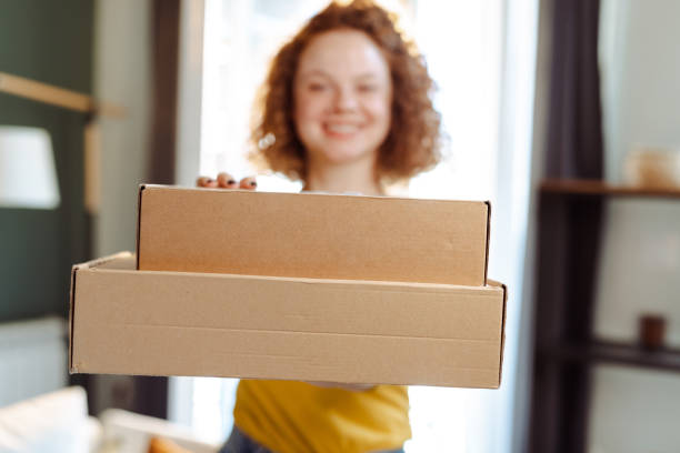 istock Female customer holding cardboard boxes at home 1477061884