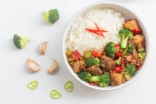istock Stir fried chicken and broccoli bell pepper has rice in bowl on white wood table. 1477066069