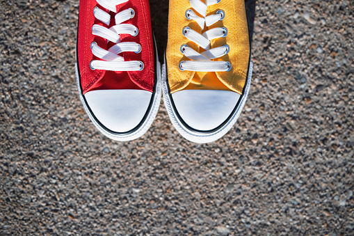 Shot of one red and one yellow canvas shoes.