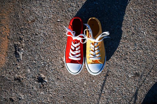 Shot of one red and one yellow canvas shoes.
