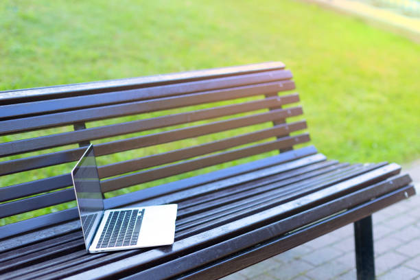 istock An open gray laptop lies on a park bench. 1477070487