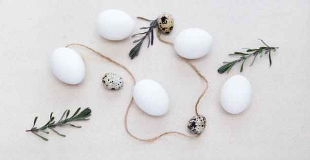 istock Easter eggs, quail eggs and tree branches in light with space for text. Natural linen fabric. 1477072550