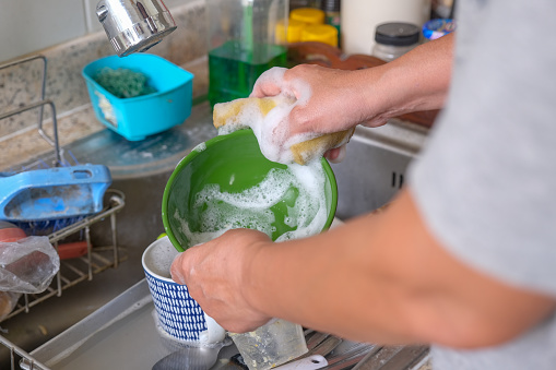 A female hands doing the dishes manually.