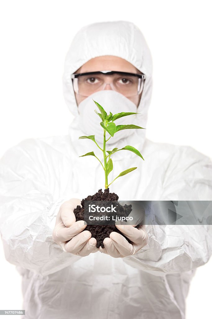 Homem vestindo um uniforme completo e segurando uma planta de pimenta - Foto de stock de Acessório ocular royalty-free