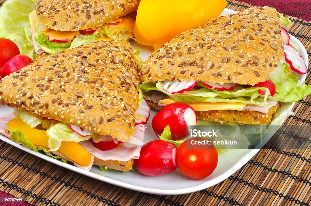 Triangle fresh sandwich with vegetable Triangle fresh sandwich with vegetable on white plate and bamboo place mat Baguette Stock Photo