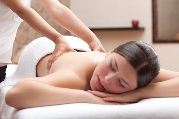 Woman enjoying back massage in a spa setting stock photo
