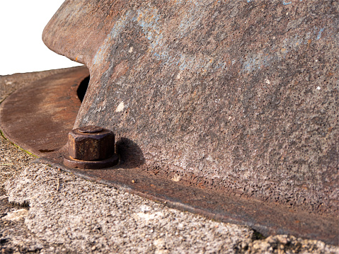 Rusty metal military bunker cap with large nuts close side view