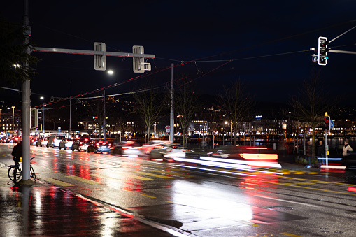 Heavy car traffic at night in a European city. Long exposure, car light trails, traffic light, late evening.