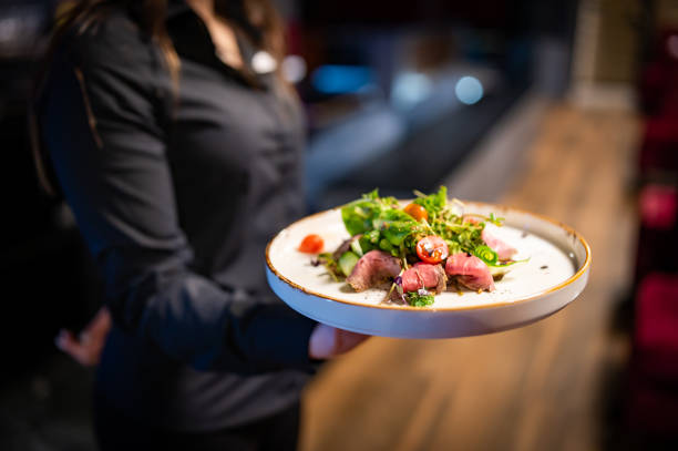 istock Waiter holds a plate with salad in the restaurant. 1477079444