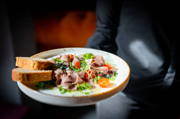 istock Waiter holds a plate with salad in the restaurant. 1477079544