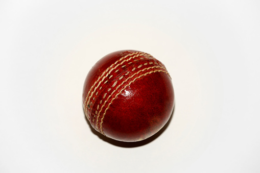Classic red cricket ball isolated on white background table view isolated on white background.