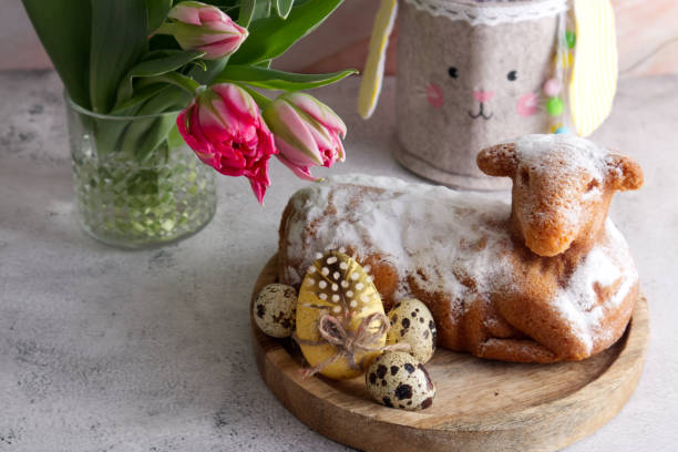 istock Easter cake in the shape of a lamb with Easter eggs and spring flowers on the table 1477080881