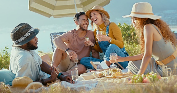Picnic, fun or spring with a friends in nature, bonding outdoor while eating and drinking alcohol. Diversity, celebration and summer with a group of people together in the countryside to relax