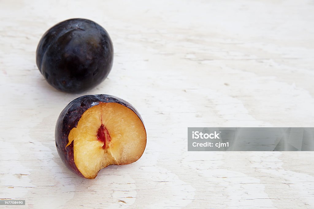 Fresh Plum fresh plums. one has a bite taken with the pit exposed. Food Stock Photo