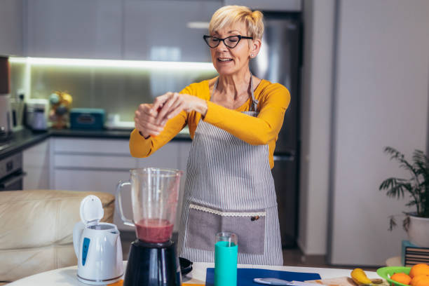 istock Senior woman preparing healthy juice 1477084978