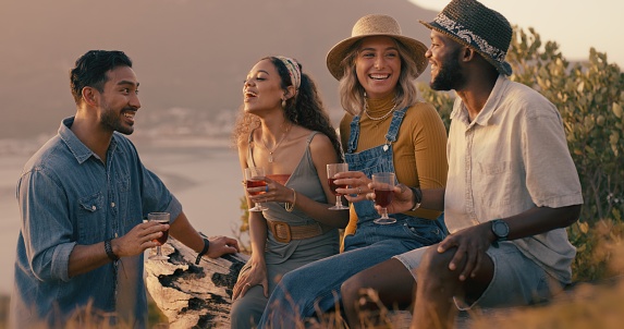 Beach party, wine glass and people with alcohol celebration, birthday or holiday talking together at ocean or in nature. Social group of friends with funny conversation or happy discussion and drinks