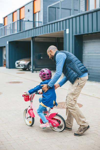 istock Father teaching his little daughter to ride a bicycle 1477085987
