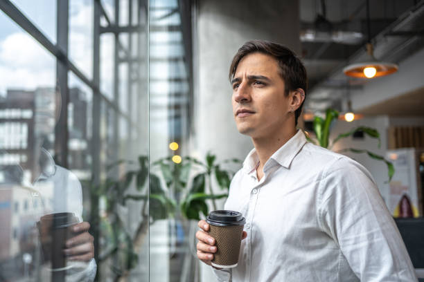 istock Young man contemplating while drink coffee at office 1477086643
