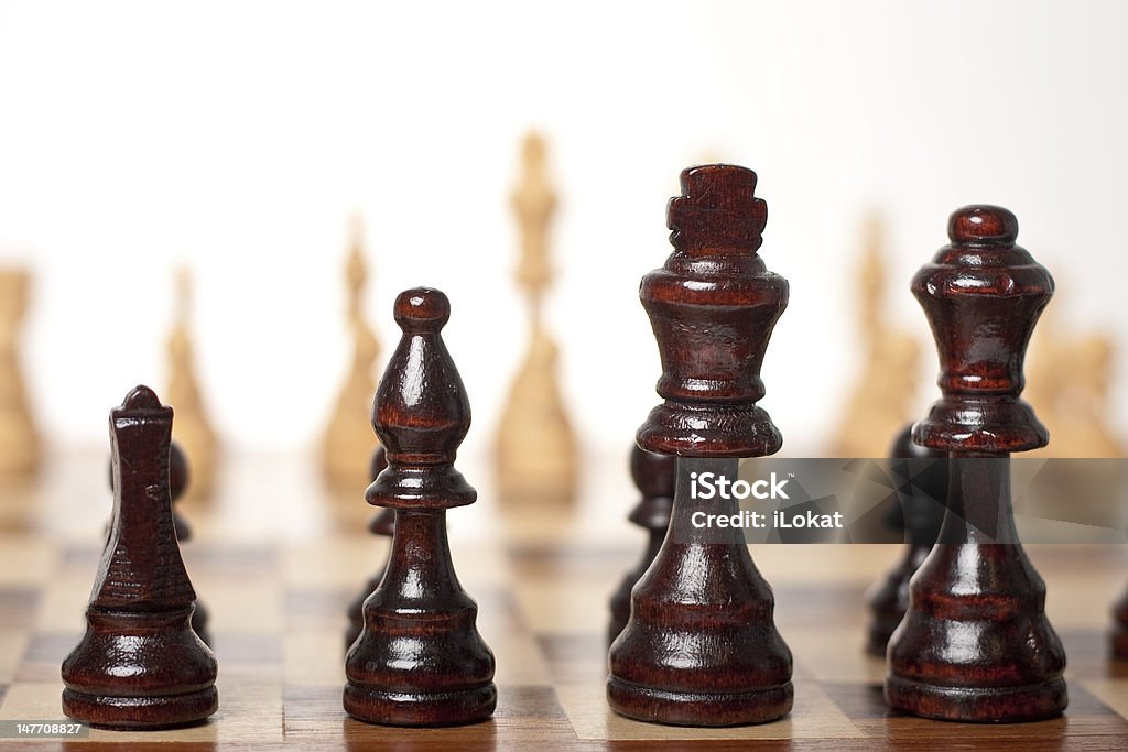 Chess Set Board Black Pieces in Focus Chess board with the black pieces in focus and the white pieces out of focus set up and ready to commence battle (high key) Bishop - Chess Piece Stock Photo