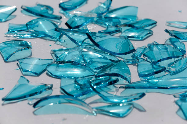 Shards of blue glass are scattered across a clean white surface.