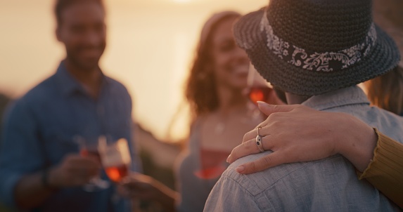 Hug, affection and friends at a party during sunset at the beach for communication and bonding. Care, social and group of people talking, speaking and having quality time together at an event