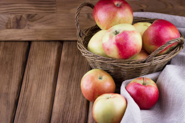 istock Apples in the basket on wooden background 1477093831