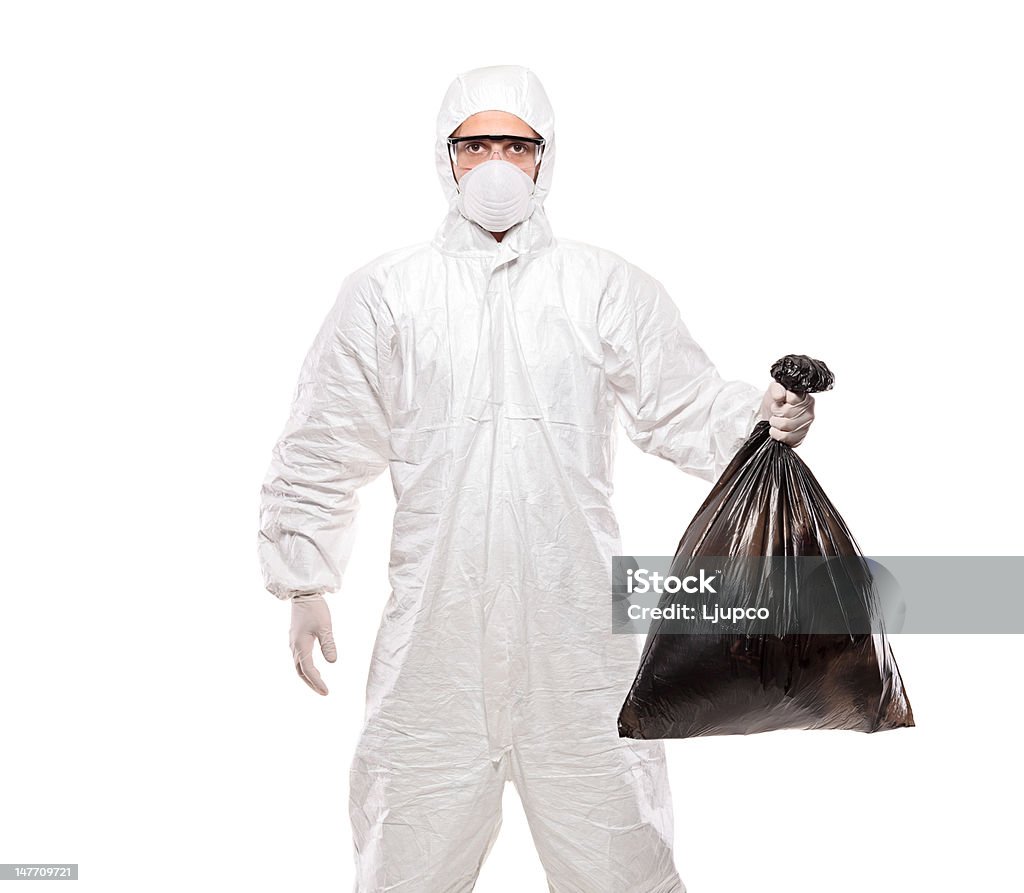 Homme en uniforme tenant un sac poubelle noirs - Photo de Bleu de travail libre de droits