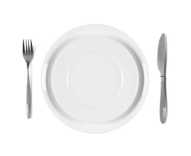 istock Two stacked white plates with fork and knife, isolated on white background 1477099854