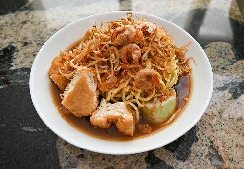 Lontong Mie is Indonesian culinary which consists of rice cake (lontong), egg noodle, fried tofu, bean sprout in shrimp garlicky stew and served with spicy sambal petis.
