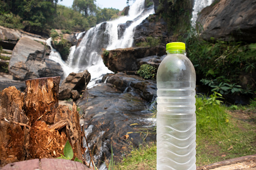 Waterfall in a Forest LandscapeWater Bottle in front of Waterfall in a Forest Landscape
