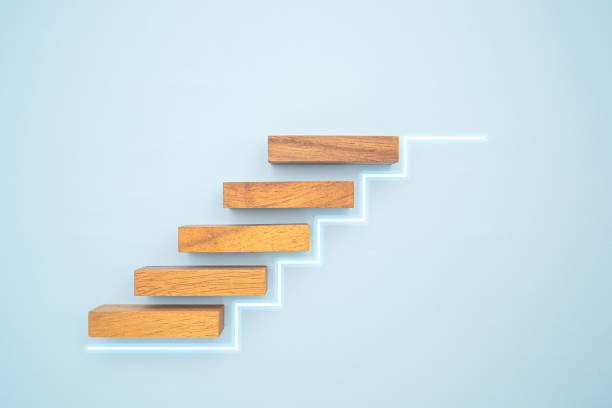 istock Wooden blocks stair with white line effect on a blue background. 1477101488