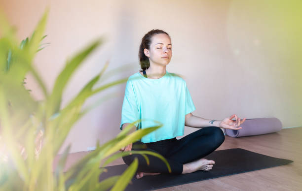 istock Brunette woman meditating in lotus pose. 1477101525