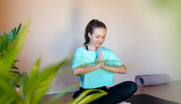 istock Young brunette woman meditating in lotus pose. 1477101541