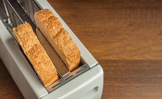 istock Rich and soft whole wheat bread in the toaster on wooden table. 1477103662