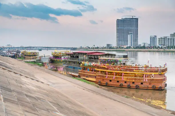Colorfully lit at dusk,on the Riverside area of Phnom Penh,used as nightspots for tourists, eating and dancing,whilst touring,brightly lit, up and down the connected Tonle Sap and Mekong rivers.