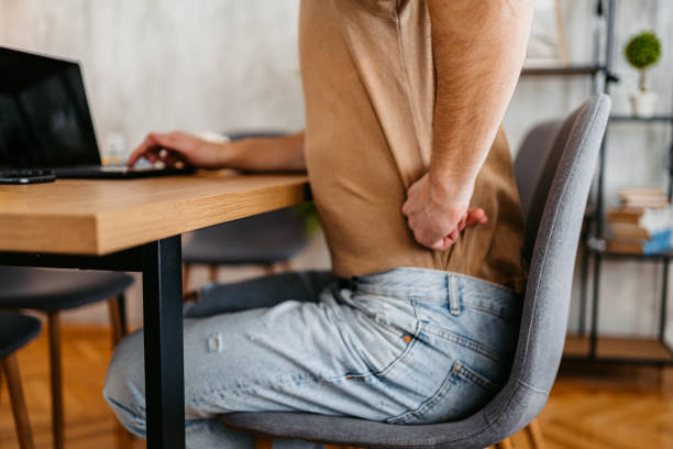 istock Tired Young Man Having Back Pain While Working On The Laptop At Home 1477110407
